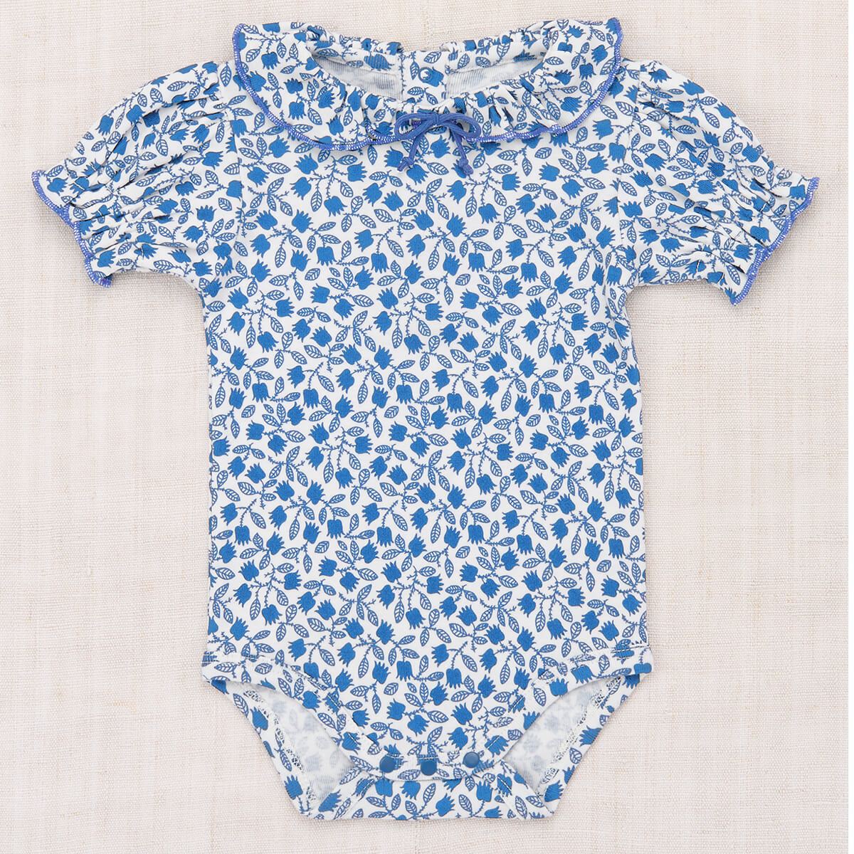 Baby Patricia Onesie in Blue Ribbon Lisse Fields by Misha & Puff